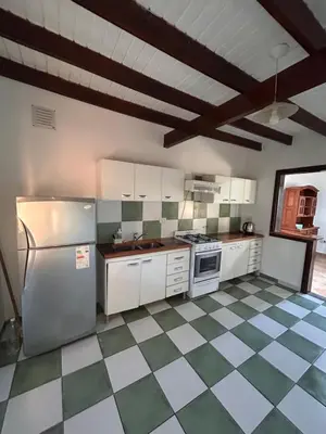 a kitchen with white appliances and a checkered floor at Casa Fiorenza in Merlo