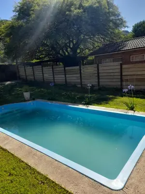 a large blue swimming pool in a yard at Depto Sierra in Santa Rosa de Calamuchita