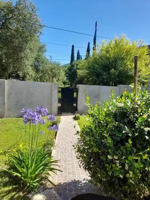 a garden with purple flowers and a brick walkway at Depto Sierra in Santa Rosa de Calamuchita