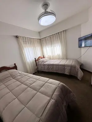 a bedroom with two beds and a large window at Departamento premium, Patio Olmos shopping !! in Cordoba
