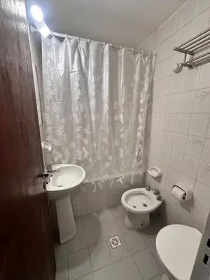 a bathroom with a sink and a toilet and a shower curtain at Departamento premium, Patio Olmos shopping !! in Cordoba