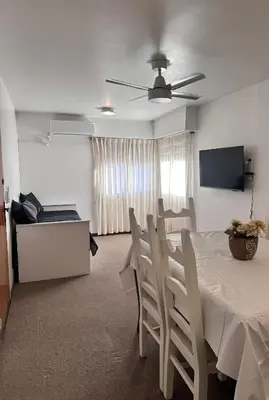 a dining room with a table and chairs and a television at Departamento premium, Patio Olmos shopping !! in Cordoba