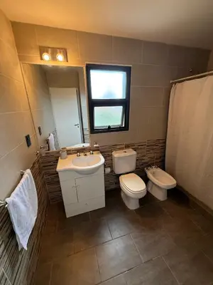 a bathroom with a sink and a toilet and a window at Nomad Base en Country Chumamaya in Merlo