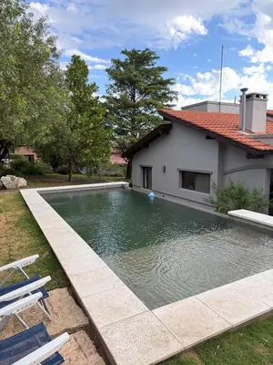 a swimming pool in front of a house at Nomad Base en Country Chumamaya in Merlo