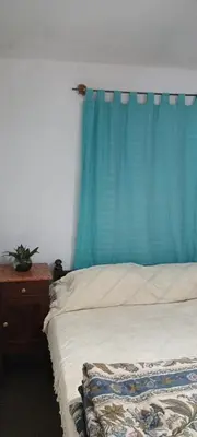 a bedroom with a bed with a blue curtain at Casa de la Nona in Cordoba
