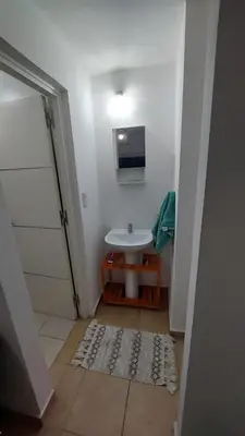 a small bathroom with a sink and a mirror at Dpto Genoma Lounge in Cordoba