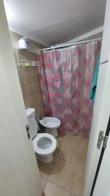 a bathroom with a toilet and a shower curtain at Dpto Genoma Lounge in Cordoba