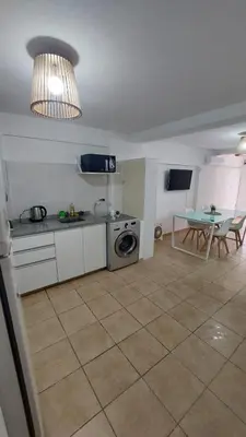 a kitchen with a washer and a table in a room at Dpto Genoma Lounge in Cordoba