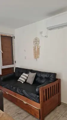 a black leather couch in a room with a window at Brisas Rumipal dúplex premium Villa Rumipal in Villa Rumipal