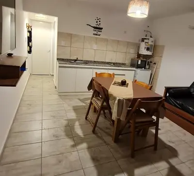 a kitchen with a table and chairs in a room at Brisas Rumipal dúplex premium Villa Rumipal in Villa Rumipal