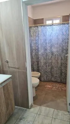 a bathroom with a toilet and a glass shower door at Brisas Rumipal dúplex premium Villa Rumipal in Villa Rumipal
