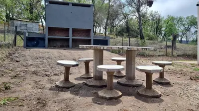 a group of tables and stools in front of a building at Brisas Rumipal Dúplex Premium in Villa Rumipal