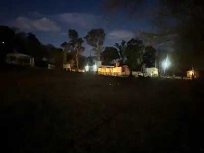 a dark field at night with a house with lights at Brisas Rumipal Dúplex Premium in Villa Rumipal
