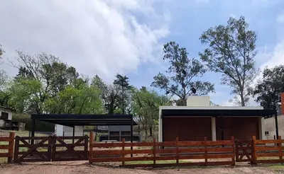 a wooden fence in front of a building at Brisas Rumipal Dúplex Premium in Villa Rumipal