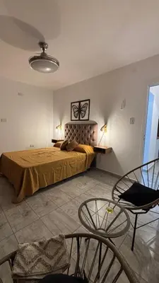 a bedroom with a bed and a table and chairs at Brisas Rumipal Dúplex Premium in Villa Rumipal