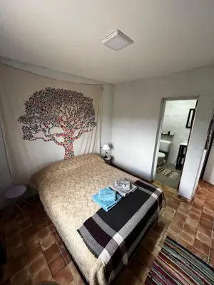 a bedroom with a large tree mural on the wall at Hostal El Portillo in Arroyo de Los Patos