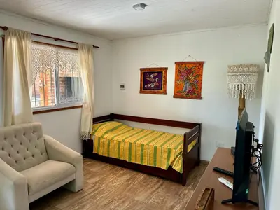 a bedroom with a bed and a chair and a tv at Cabañas Enki in La Paz