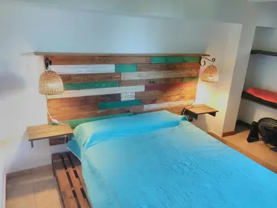 a bedroom with a blue bed with a wooden headboard at Casa Amapola in Embalse