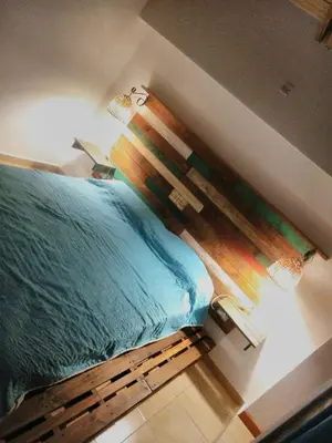 a bedroom with a bed with a wooden headboard at Casa Amapola in Embalse