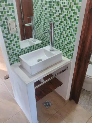 a bathroom with a sink and a green wall at Casa Amapola in Embalse