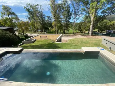 a swimming pool in a park with a picnic table at Casa en Molvento in Villa Los Molinos
