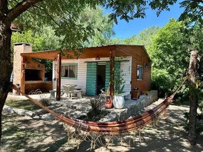 a hammock in front of a log cabin at Cabañas Enki in La Ramada