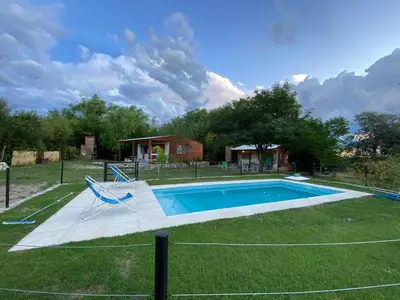 a swimming pool in the middle of a yard at Cabañas Enki in La Ramada
