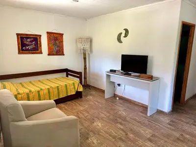 a living room with a bed and a television at Cabañas Enki in La Ramada