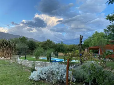 a garden with a swimming pool and a house at Cabañas Enki in La Ramada