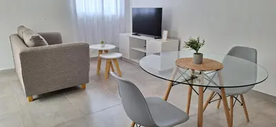 a living room with a glass table and chairs at Moderno departamento a estrenar in Alta Gracia