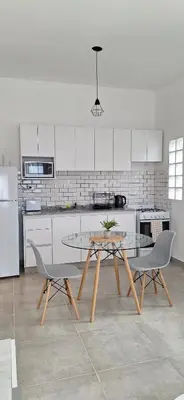 a kitchen with a table and two chairs in it at Moderno departamento a estrenar in Alta Gracia
