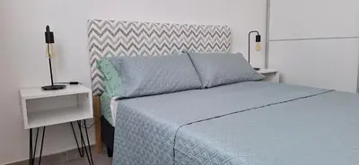 a bedroom with a bed with a blue comforter at Moderno departamento a estrenar in Alta Gracia