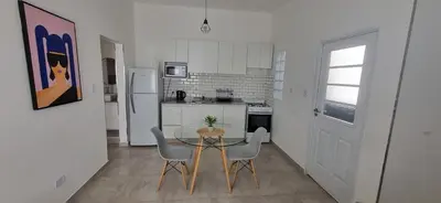 a kitchen with a glass table and chairs in a room at Moderno departamento a estrenar in Alta Gracia