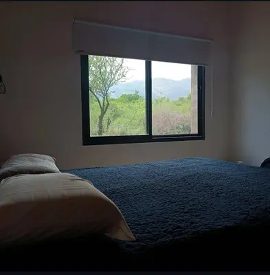 a bedroom with a bed and a window with a view at El buen retiro in Villa de Las Rosas