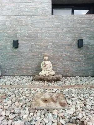 a statue of a person sitting on a rock at El buen retiro in Villa de Las Rosas