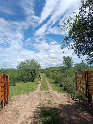 a couple of people walking down a dirt road at El buen retiro in Villa de Las Rosas