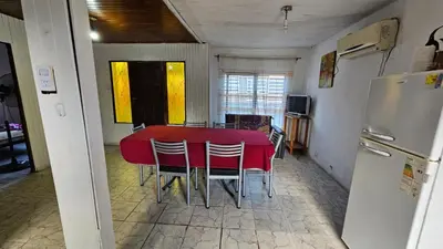 a kitchen with a red table and chairs and a refrigerator at Altos de Grecia Cabaña 1 in Villa Carlos Paz