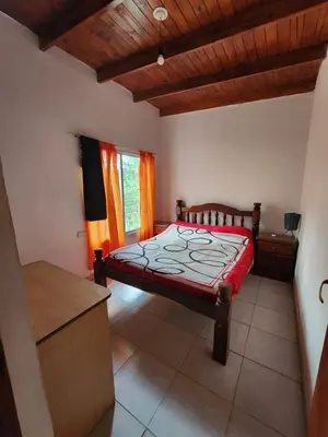 a bedroom with a bed in a room with wooden ceilings at Altos de Grecia Cabaña 2 in Villa Carlos Paz