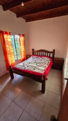 a bedroom with a bed in a room with two windows at Altos de Grecia Cabaña 2 in Villa Carlos Paz