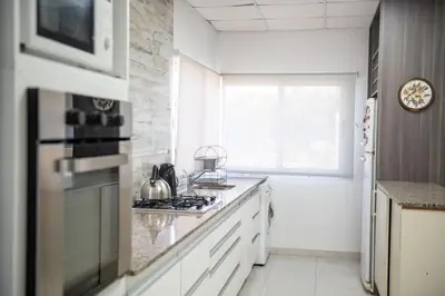 a kitchen with white counters and a stove top oven at Sierras Country Golf in San Antonio de Arredondo