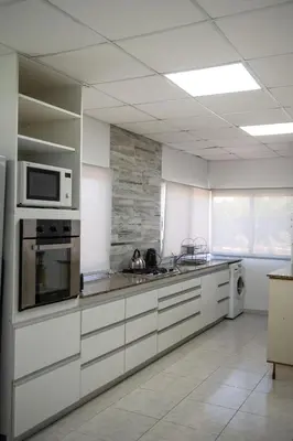 a kitchen with white cabinets and a microwave at Sierras Country Golf in San Antonio de Arredondo