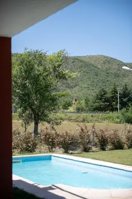 a blue swimming pool with a hill in the background at Sierras Country Golf in San Antonio de Arredondo
