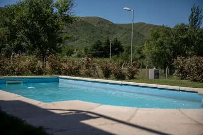 a swimming pool in a yard with mountains in the background at Sierras Country Golf in San Antonio de Arredondo