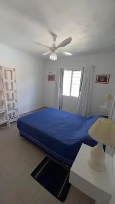 a bedroom with a blue bed and a ceiling fan at Cabaña Trébol en Cabañas Encuentro in Carpintería