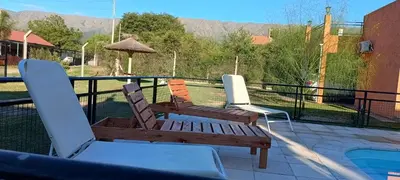 two chairs and a wooden bench on a patio at Cabaña Trébol en Cabañas Encuentro in Carpintería