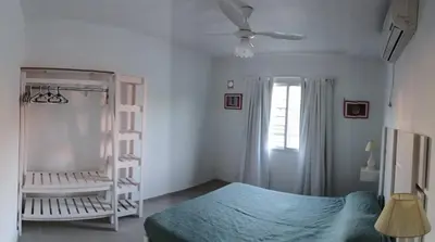 a bedroom with a bed and a fan and a window at Cabaña Trébol en Cabañas Encuentro in Carpintería