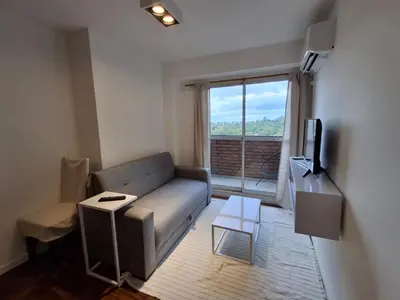 a living room with a couch and a large window at Excepcional departamento en Nueva Córdoba in Cordoba