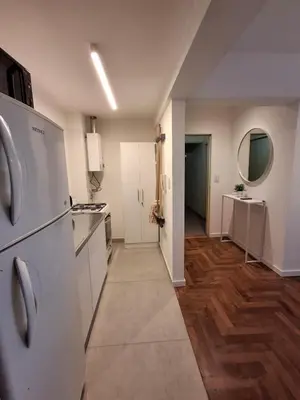 a kitchen with white appliances and wooden floors at Excepcional departamento en Nueva Córdoba in Cordoba