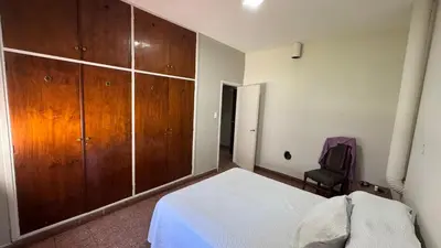 a bedroom with a bed and a large wooden cabinet at La casa de Rena in Santa Rosa de Calamuchita