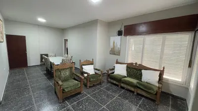 a living room with chairs and a table and a window at La casa de Rena in Santa Rosa de Calamuchita